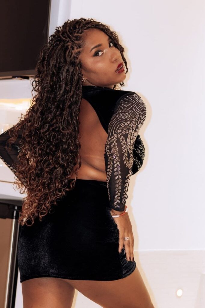 Aisha, una escort disponibile 24 ore su 24, posa di spalle con un vestito a Malaga