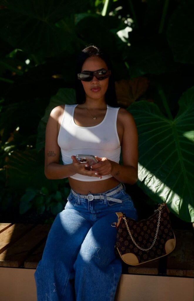 Jade, een escortdame, draagt een donkere zonnebril en een kort wit topje in Malaga