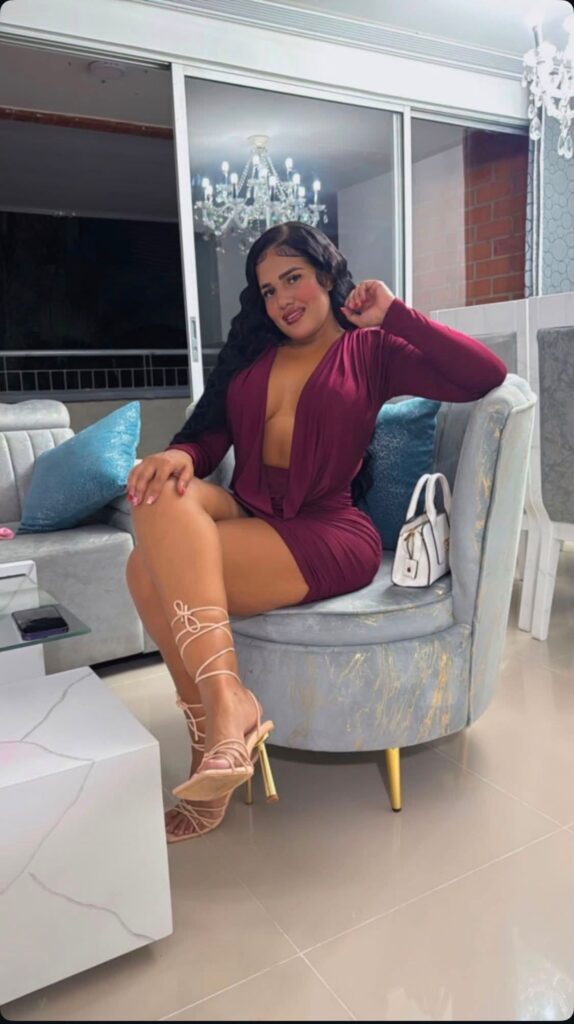 Nicole, escort, posa seduta con un vestito su Mujeresconclase