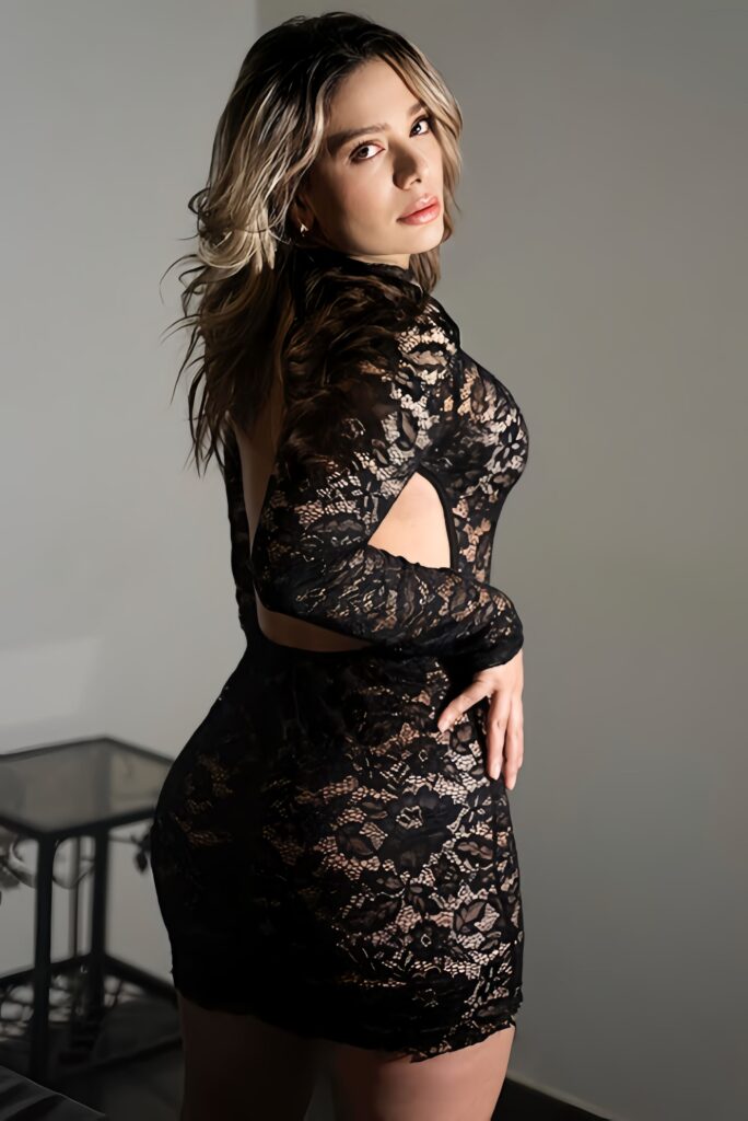 Paula, escort pozująca na plecach i spoglądająca przez ramię do kamery w Maladze