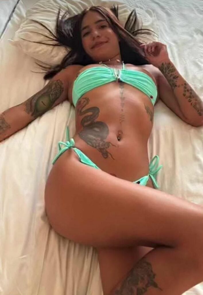 Paulina, quella escort, è sdraiata su un letto con lenzuola bianche a Malaga