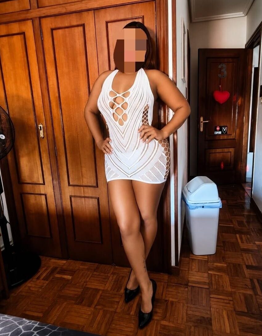 Laura, escort posa en una habitación de Mujeresconclase en vestido