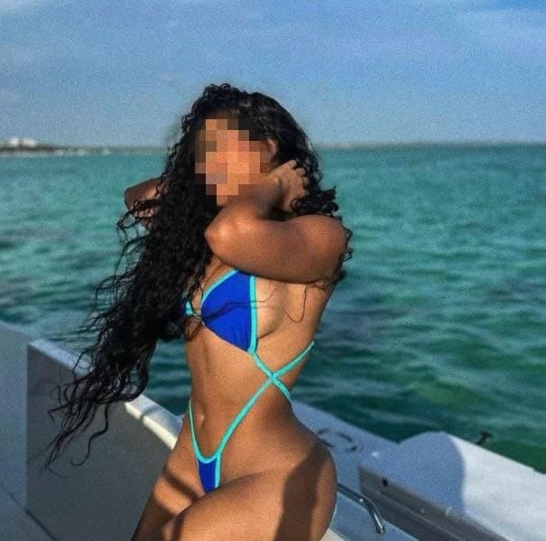Tatiana, puta con cabello largo, rizado y oscuro posa a bordo de un yate en el mar en Malaga
